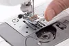 A close-up view of a person's finger interacting with the needle and presser foot of a sewing machine. Produktbild-Vorschau