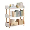 A three-tiered white bookshelf with wooden accents, filled with books and decorative items. Produktbild-Vorschau