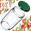 A glass jar with a green lid is shown surrounded by various fresh vegetables and herbs. Podgląd zdjęcia produktu