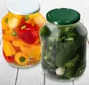 Two jars of preserved food, one with peppers and the other with pickles, are displayed on a wooden surface. Produktbild-Vorschau