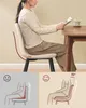 A woman sitting at a table reading a book, with diagrams below illustrating good and bad posture while sitting. Produktbild-Vorschau