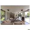 A modern living room with large glass windows overlooking a garden and pool. Produktbild-Vorschau