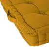 A close-up view of a mustard yellow floor cushion, showing its tufted texture and stitched edges. Náhled obrázku produktu
