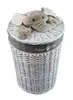 A white wicker laundry basket with a plush elephant toy on top. Podgląd zdjęcia produktu