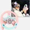 Rosa und hellblaues Spielzeuglenkrad, mit einem Kind, das im Hintergrund in einem Autositz mit einem ähnlichen Spielzeug spielt Náhľad obrázku produktu