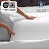 Hands adjusting a white pillow on a bed. Produktbild-Vorschau