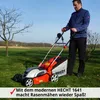 A man is using an electric lawnmower in a grassy field on a sunny day. Produktbild-Vorschau