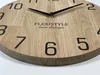 Close-up of a wooden wall clock with black hands and numbers. Voir les images du produit