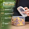 A person is holding a clear plastic food storage container filled with cereal. The background features a green leafy plant and a wooden surface. Text overlays highlight product features. Anteprima dell’immagine prodotto