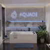 A modern bathroom with a large bathtub, illuminated by blue LED lights and a neon sign. Produktbild-Vorschau