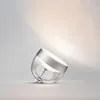 A single Philips Hue Iris table lamp is shown tilted on a light gray surface against a light gray wall. Produktbild-Vorschau