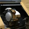 A close-up view of a complex industrial machine part, likely a lathe chuck or tool holder, with various metallic components and cutting tools. Anteprima dell’immagine prodotto