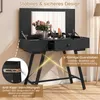 A black vanity table with a mirror, makeup, and flowers, set against a light gray and white background. Podgląd zdjęcia produktu