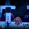 A person's hand is on a keyboard next to a microphone, suggesting a streaming or recording setup. Anteprima dell’immagine prodotto