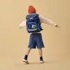 A young boy wearing a backpack and a beanie, dancing. Voir les images du produit