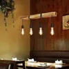 A dining table setting with a wooden beam pendant light hanging above. Anteprima dell’immagine prodotto