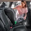 A woman is installing a child car seat in the back seat of a car. Náhled obrázku produktu