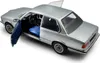 A silver BMW 323I E21 model car with its doors open, showing the blue interior. Anteprima dell’immagine prodotto