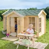 Two children playing in and around a wooden playhouse with a picnic table in front. Produktbild-Vorschau