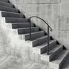A concrete staircase with a black metal handrail. Voir les images du produit