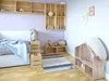 A child's bedroom with a bed, wooden crates used as shelves and storage, a rug, and a dollhouse. Produktbild-Vorschau