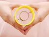 Hands holding a yellow corn kernel remover. Produktbild-Vorschau