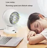 A woman is sleeping next to a desk with a laptop and a white desk fan running. Produktbild-Vorschau