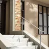 A close-up view of a modern staircase with a stainless steel railing and marble steps, leading up to a building entrance. Produktbild-Vorschau