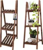 Two wooden plant stands are shown side-by-side against a white background. The left stand is empty, while the right stand is decorated with plants, books, and a camera. Produktbild-Vorschau