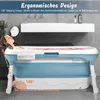 A woman is relaxing in a portable bathtub in a bathroom setting. The bathtub is blue and white and appears to be foldable. Produktbild-Vorschau
