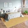 A bedroom scene with a bed, rug, and decor. Produktbild-Vorschau