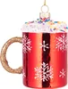 A close-up of a red glass Christmas ornament shaped like a mug with white frosting and colorful sprinkles on top, and snowflakes on the side. Produktbild-Vorschau