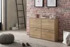 A shoe cabinet with four drawers is placed against a brick wall in a room with a ladder and a pouf. Produktbild-Vorschau