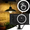 A solar-powered hanging lamp is shown mounted on a stone wall, with a close-up inset highlighting a button and the back of the solar panel. Anteprima dell’immagine prodotto