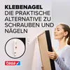 A woman is holding a framed picture, about to hang it on a wall using tesa adhesive nails. The image highlights the product's ease of use and practicality. Náhled obrázku produktu