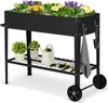 A black metal raised garden bed with plants and gardening tools. Voir les images du produit