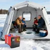 People ice fishing inside a tent with a heater. Voir les images du produit