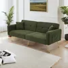 A green sofa with gold legs is shown in a well-lit room with a painting on the wall and plants. Anteprima dell’immagine prodotto