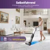 A woman is using a cordless vacuum cleaner in a modern, well-lit living room. Produktbild-Vorschau
