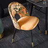 A close-up shot of a designer dining chair with a floral pattern on the backrest and a velvet seat. Produktbild-Vorschau