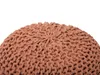 A close-up view of a round, knitted pouf. Produktbild-Vorschau