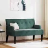 A dark green velvet Chesterfield bench with a white pillow sits on a light rug in a room with a painting on the wall and a small side table. Podgląd zdjęcia produktu