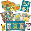 A collection of Pokemon TCG items including booster packs, cards, a storage box, and a Pikachu figure. Produktbild-Vorschau