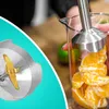 A split image showing a close-up of a blender blade on the left and a hand holding a blender in a beaker with orange slices on the right. Produktbild-Vorschau