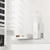 Two white USB chargers are placed on a white shelf in front of a white background with light filtering through blinds. Podgląd zdjęcia produktu