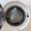 Close-up view of a washing machine drum with a patterned rug inside. Produktbild-Vorschau
