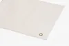 A close-up shot of a beige fabric with a metal grommet in the corner, set against a white background. Produktbild-Vorschau