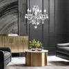 A luxurious living room with a crystal chandelier, a gold cabinet, a marble-topped coffee table with decorative items, and leather armchairs. Anteprima dell’immagine prodotto