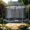 A KETTLER trampoline is set up in a backyard garden with flowers and a house in the background. Produktbild-Vorschau