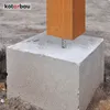 A wooden post is anchored into a concrete base in the ground. Anteprima dell’immagine prodotto